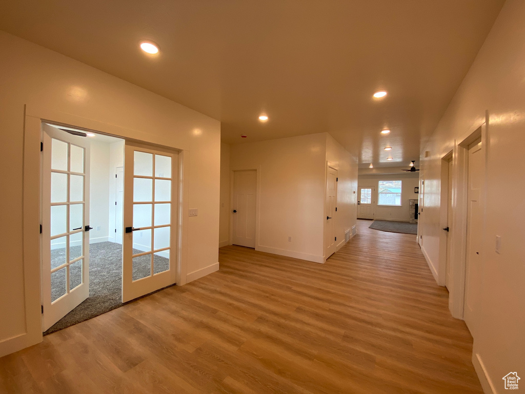 Empty room with light hardwood / wood-style flooring, ceiling fan, and french doors