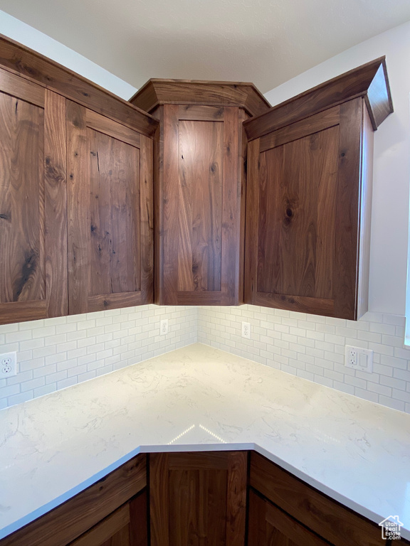 Kitchen featuring tasteful backsplash and light stone counters