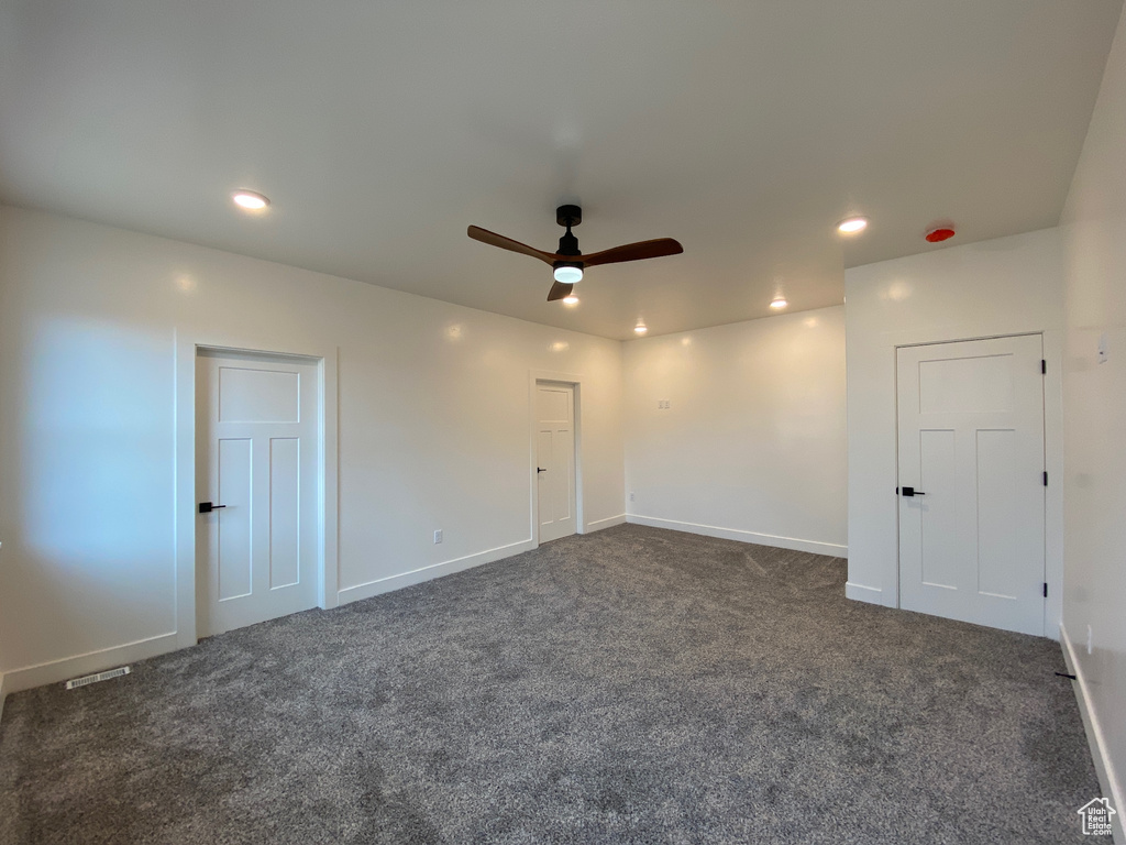 Empty room with ceiling fan and carpet flooring