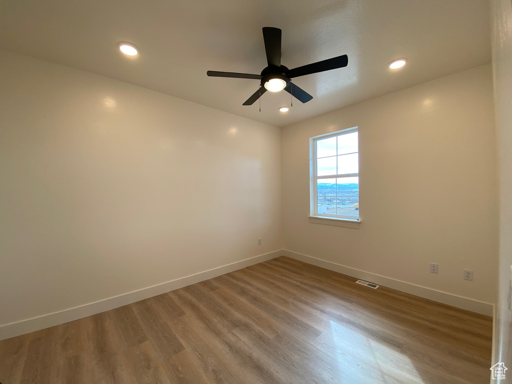 Empty room featuring hardwood / wood-style floors and ceiling fan