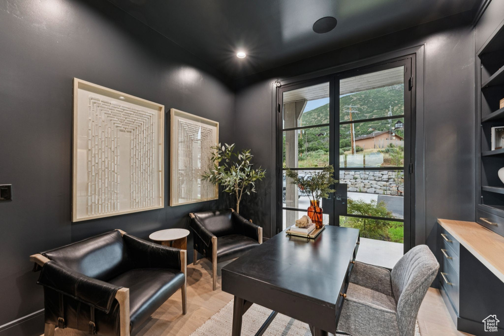 Office area with light wood-style floors and recessed lighting