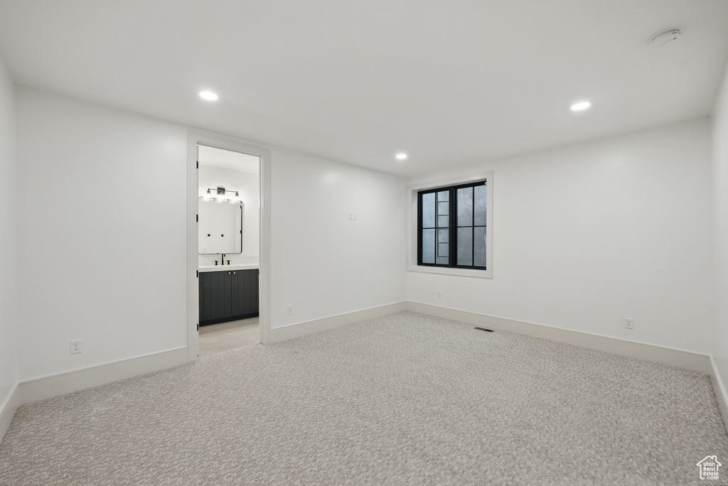 Empty room featuring recessed lighting, light carpet, baseboards, and a smoke detector
