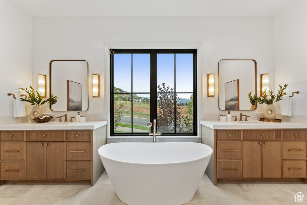 Full bathroom featuring two vanities and a soaking tub
