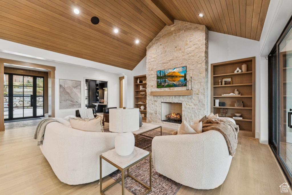 Living room featuring a wooden ceiling with exposed beams, light wood-style floors, recessed lighting, a fireplace, and high vaulted ceiling
