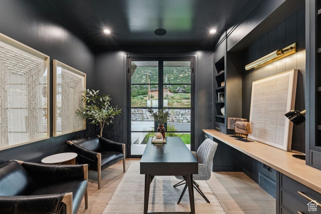 Home office with built in features, light wood-type flooring, and recessed lighting