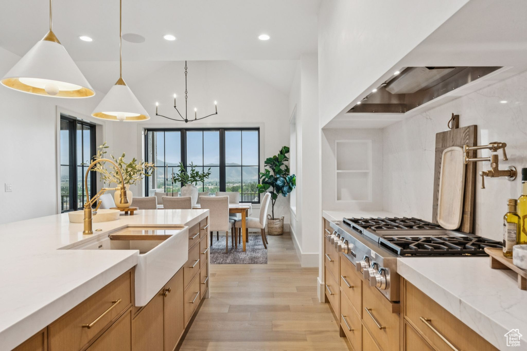 Kitchen with light wood-style floors, recessed lighting, a chandelier, hanging light fixtures, and ventilation hood