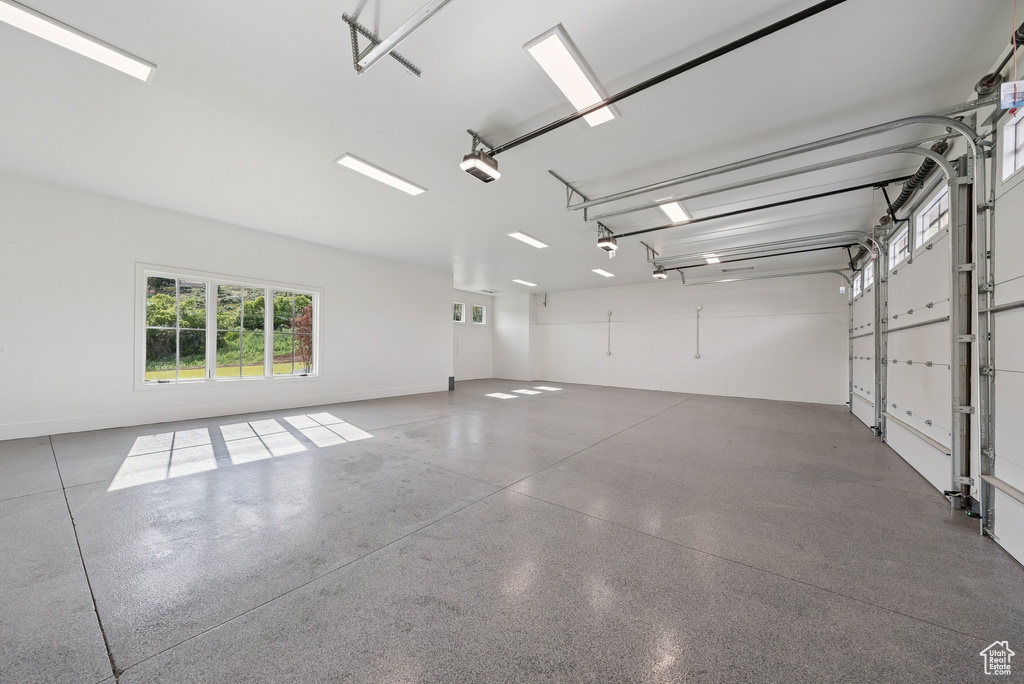 Garage with baseboards and a garage door opener