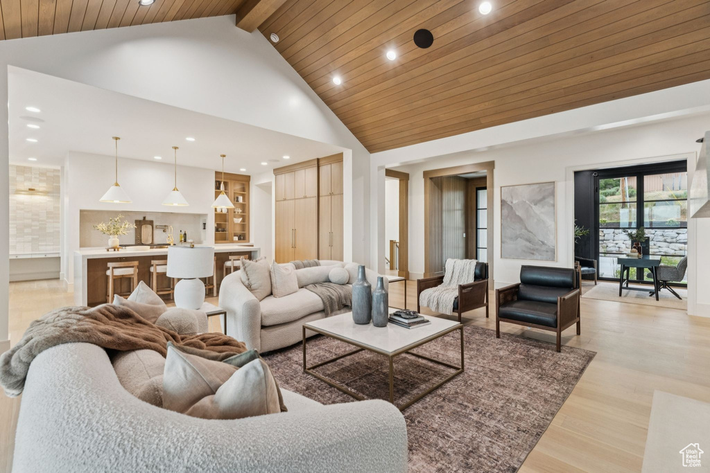 Living area featuring high vaulted ceiling, recessed lighting, wooden ceiling, and light wood-style floors