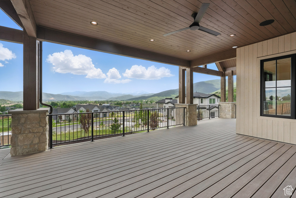 Deck with a mountain view, a ceiling fan, and a residential view