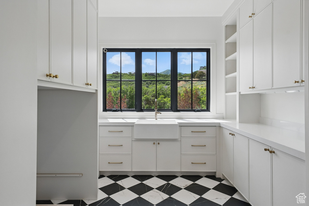 Kitchen featuring open shelves, white cabinetry, and light countertops
