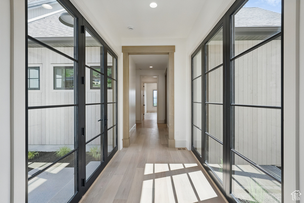 Hall with wood finished floors, baseboards, and recessed lighting