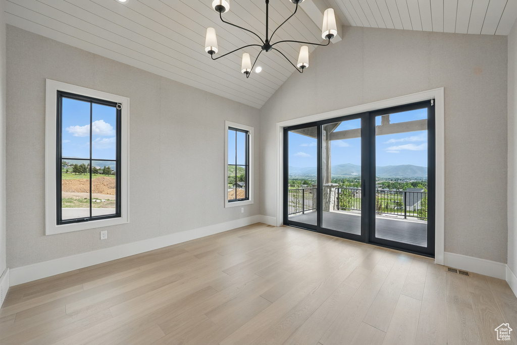Spare room featuring healthy amount of natural light, wood finished floors, baseboards, a mountain view, and wood ceiling