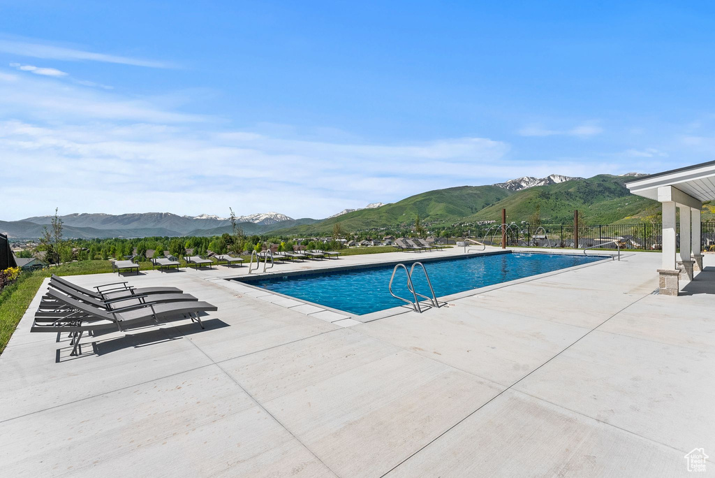 View of swimming pool with a mountain view and a patio