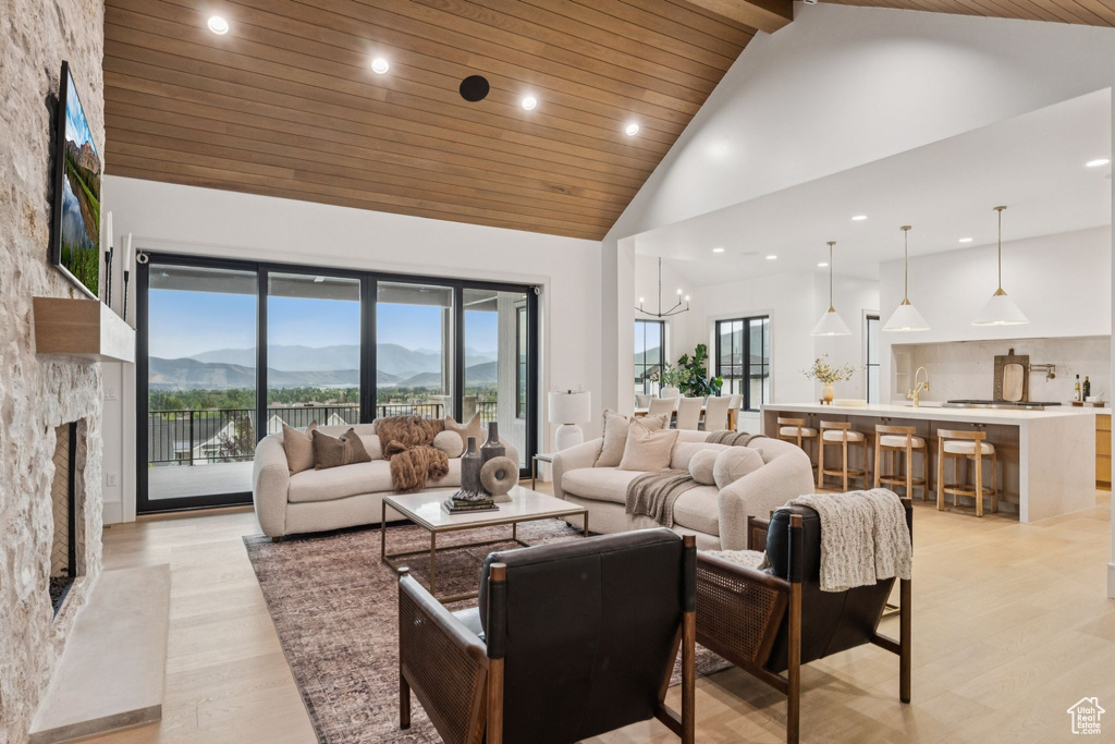 Living area featuring high vaulted ceiling, a fireplace, a mountain view, wooden ceiling, and recessed lighting