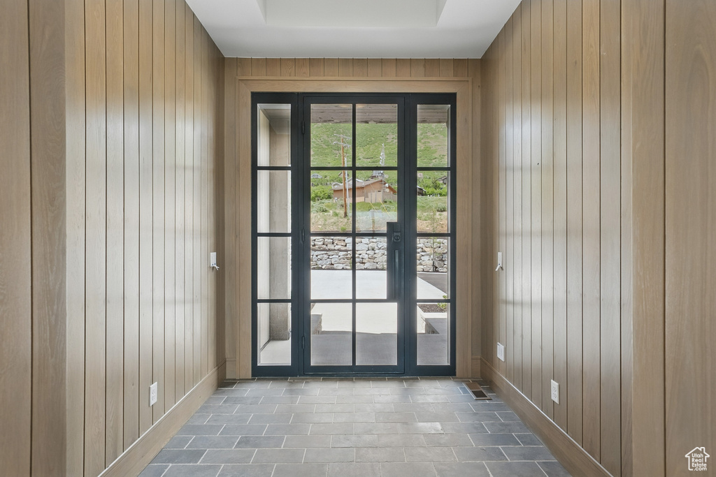 Doorway to outside featuring wooden walls