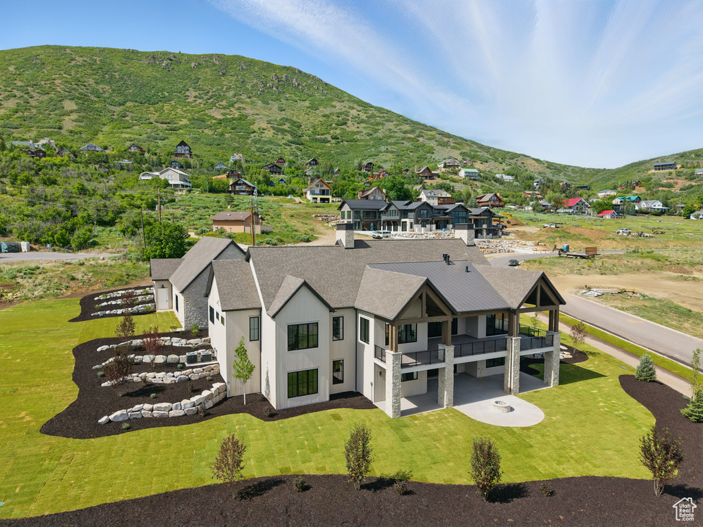 Aerial view of property and surrounding area featuring a mountain backdrop