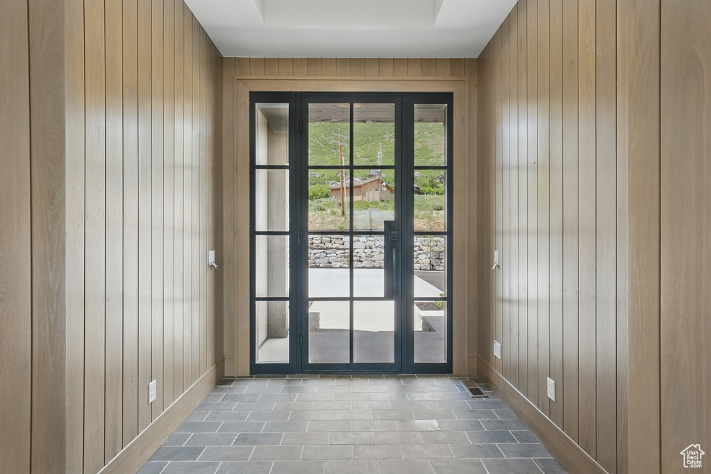 Doorway with wood walls and baseboards