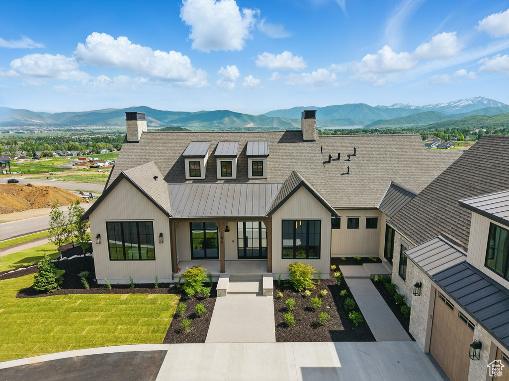 Modern inspired farmhouse with a chimney, a mountain view, and a porch