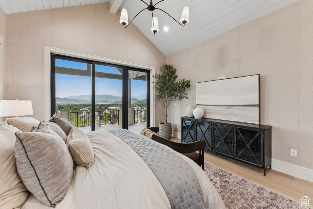 Bedroom with high vaulted ceiling, wood finished floors, access to exterior, a chandelier, and beam ceiling