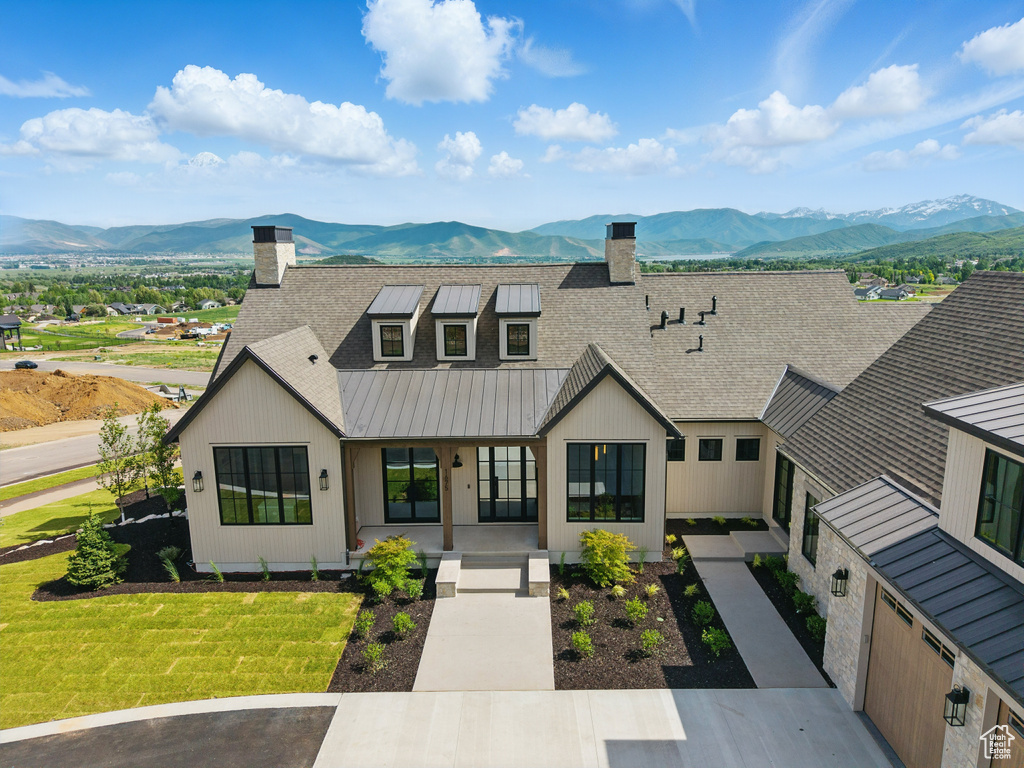 Modern inspired farmhouse featuring a chimney, a mountain view, and covered porch