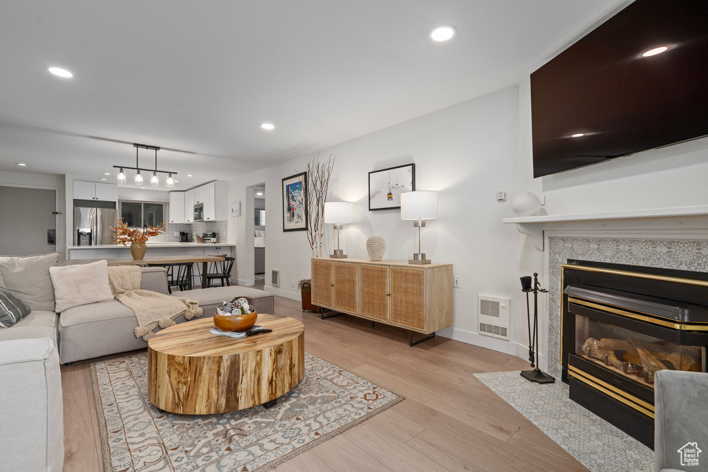 Living room featuring light wood-type flooring and a fireplace