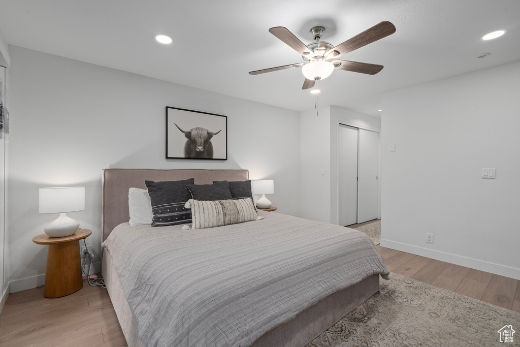 Bedroom with light wood-type flooring, a closet, and ceiling fan