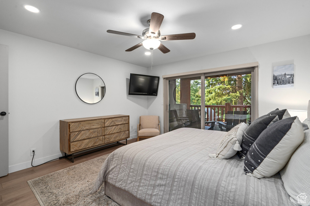 Bedroom with wood-type flooring, access to exterior, and ceiling fan