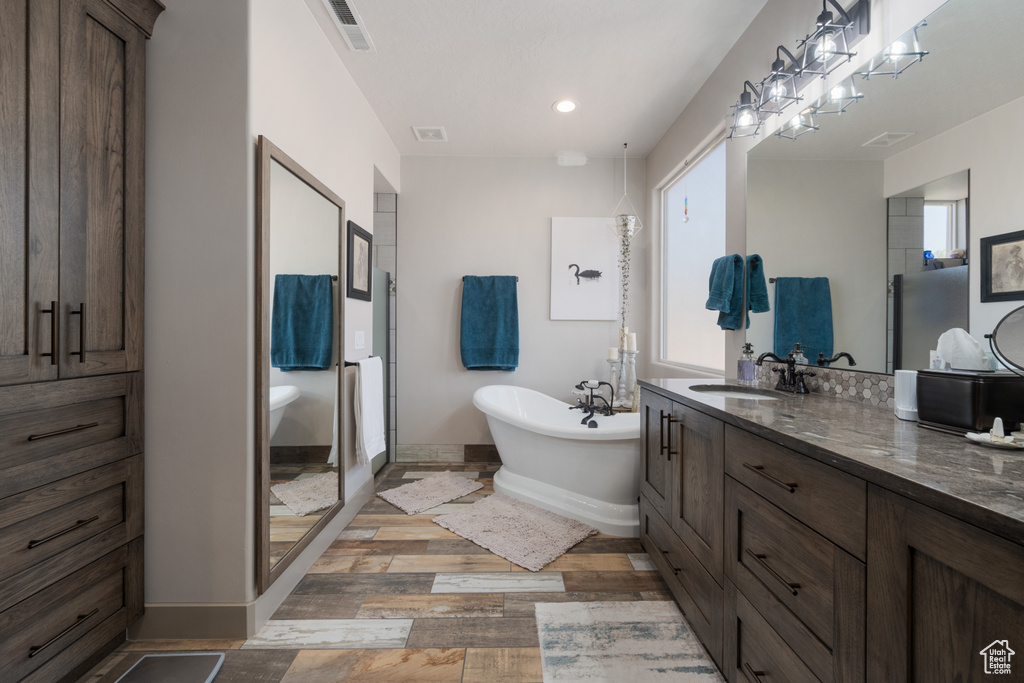 Bathroom featuring vanity, wood-type flooring, and independent shower and bath