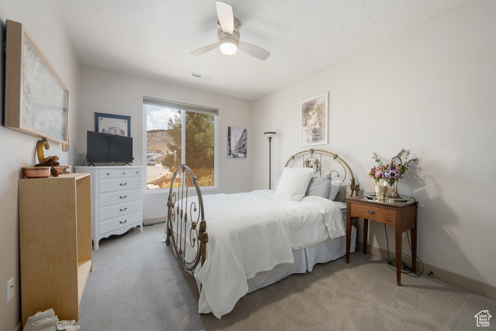 Carpeted bedroom featuring ceiling fan