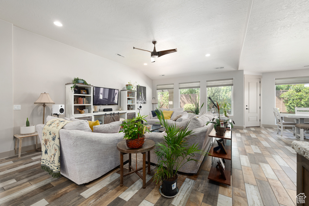 Living room with ceiling fan, hardwood / wood-style flooring, and a textured ceiling