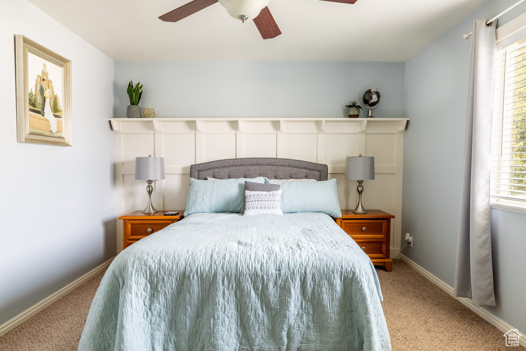 Bedroom featuring multiple windows, ceiling fan, and light carpet