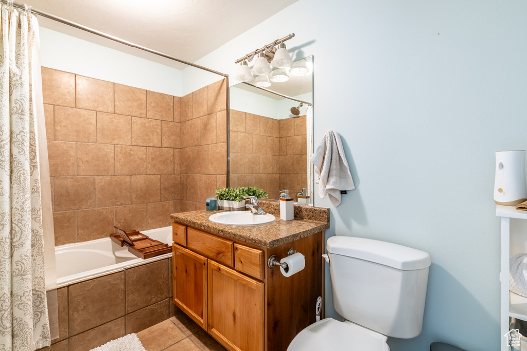 Full bathroom with vanity, toilet, tile patterned flooring, and shower / bath combo with shower curtain