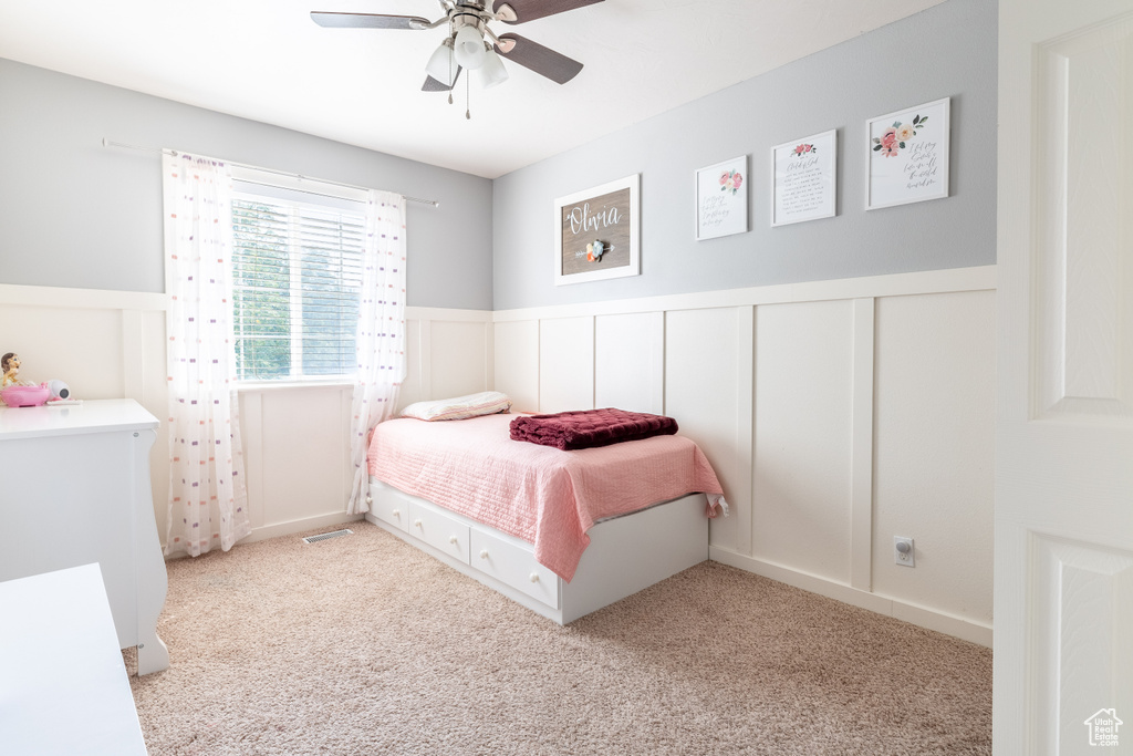 Carpeted bedroom featuring ceiling fan