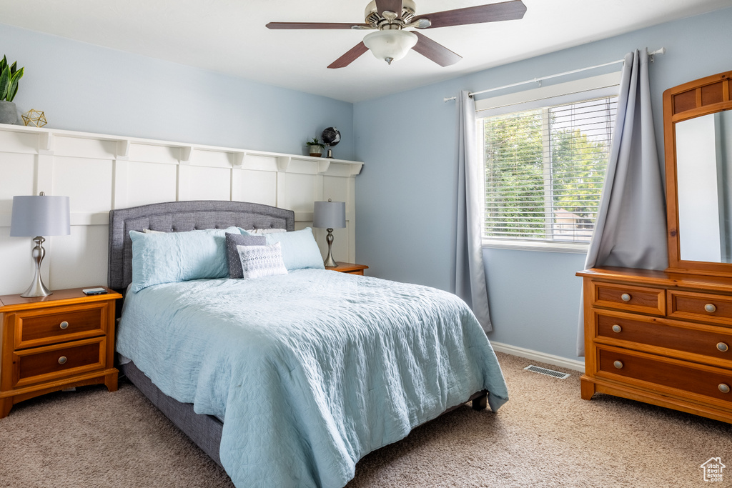 Carpeted bedroom featuring ceiling fan