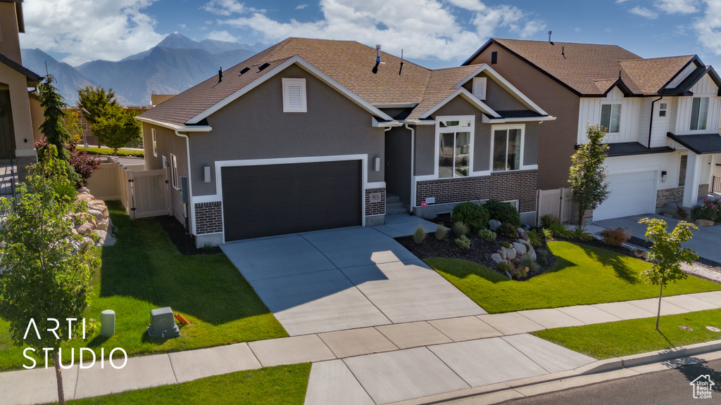 Craftsman inspired home with a mountain view, a front yard, and a garage