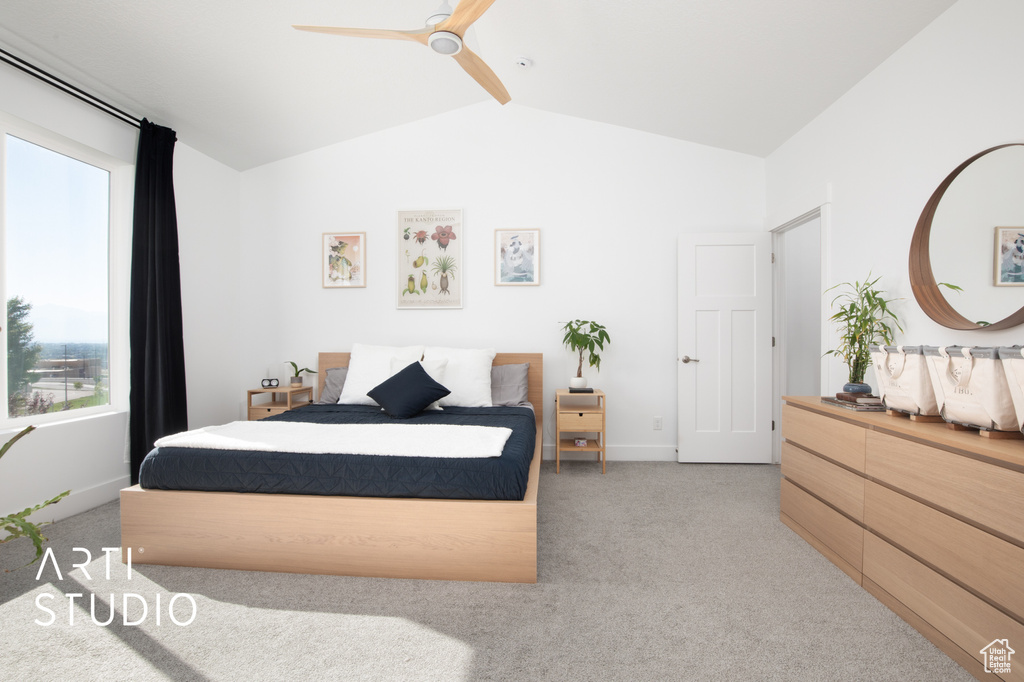 Bedroom with ceiling fan, light carpet, and vaulted ceiling