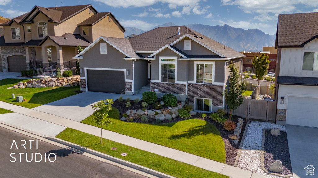 Craftsman-style home featuring a mountain view, a garage, and a front yard