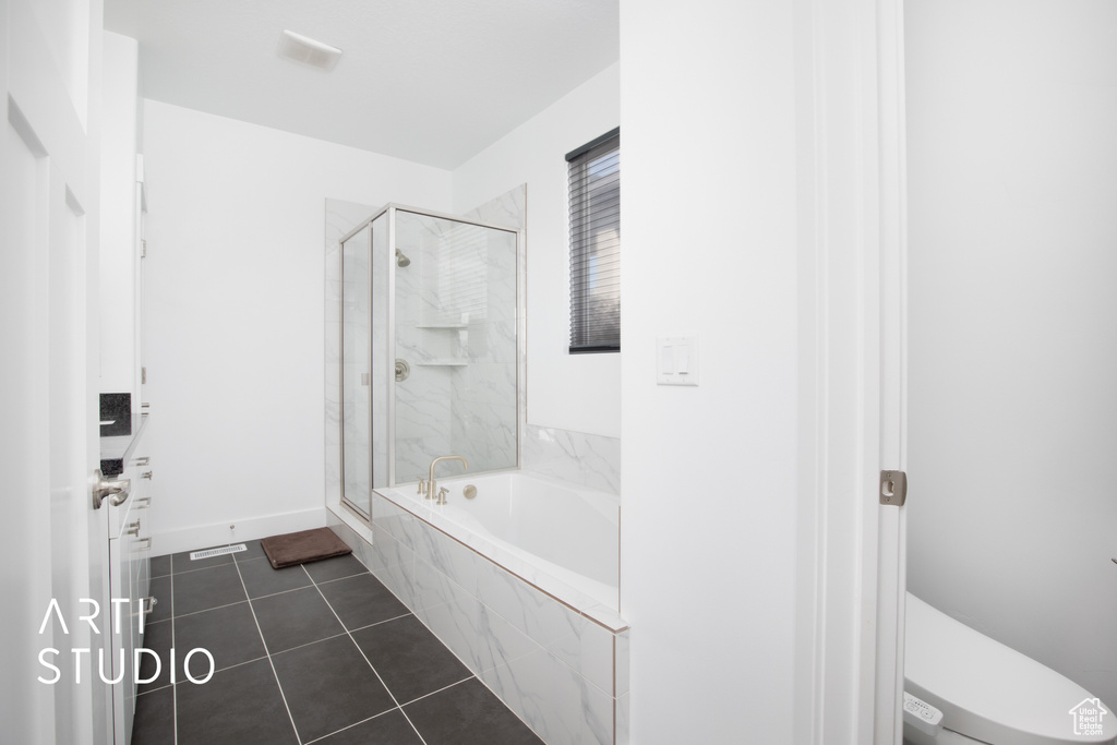 Bathroom with toilet, separate shower and tub, and tile patterned floors