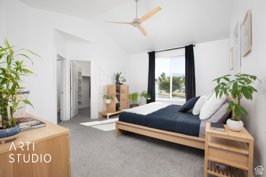 Carpeted bedroom featuring lofted ceiling, ceiling fan, a spacious closet, and ensuite bath