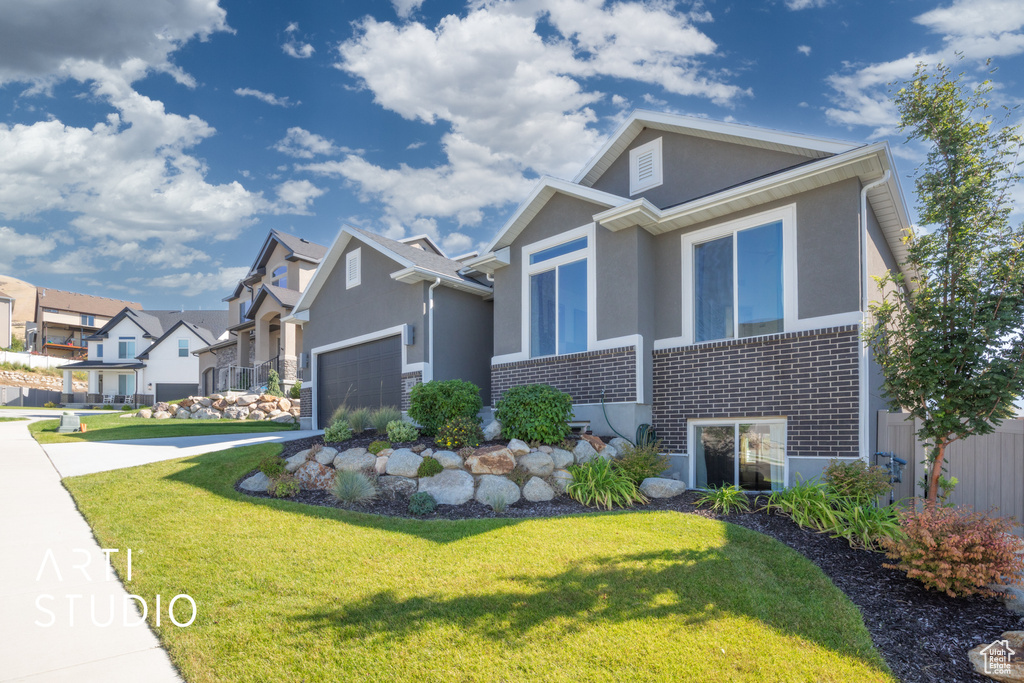 View of front of home featuring a front lawn and a garage