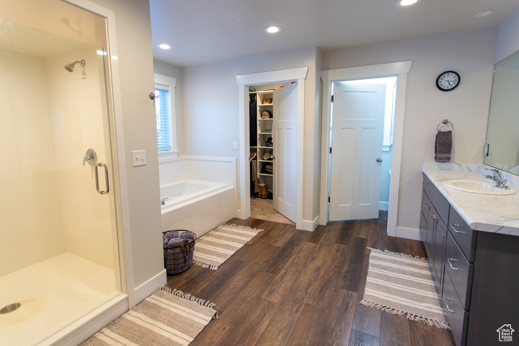 Bathroom with vanity, hardwood / wood-style floors, and independent shower and bath