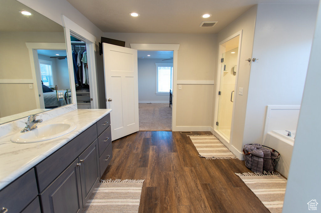 Bathroom featuring separate shower and tub, hardwood / wood-style flooring, and vanity