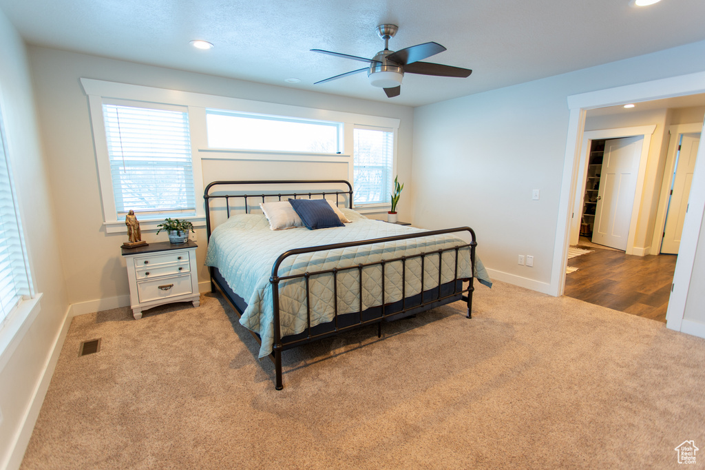 Bedroom featuring multiple windows, ceiling fan, and light hardwood / wood-style floors