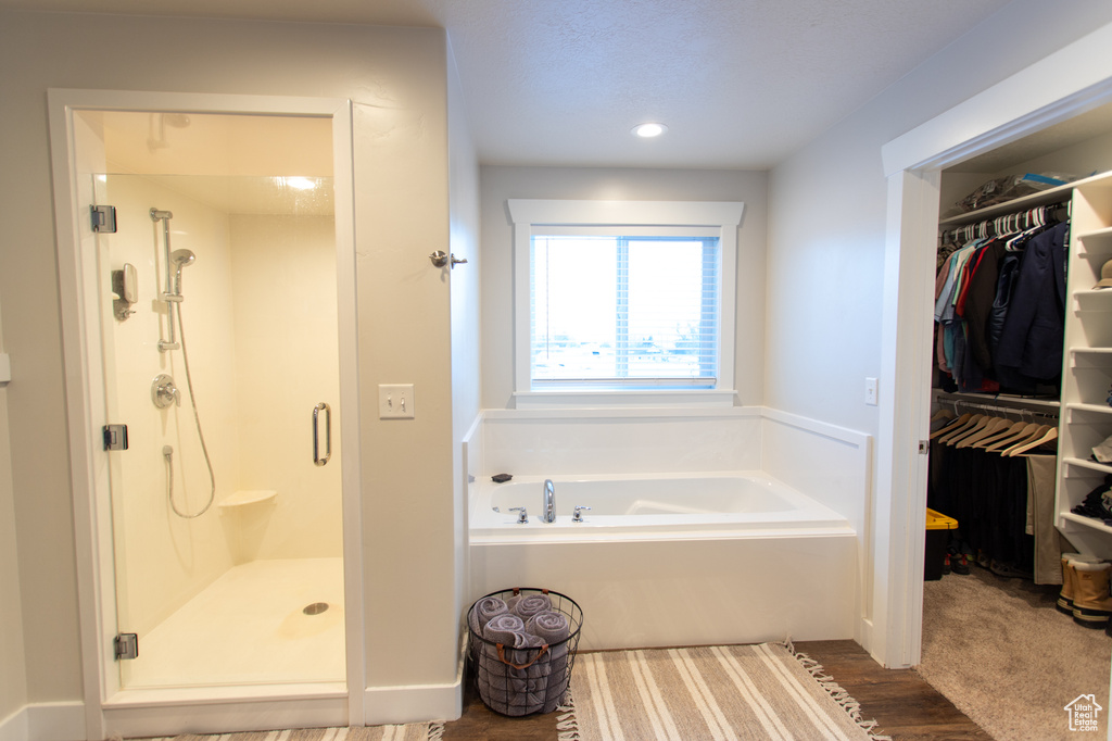 Bathroom featuring independent shower and bath and hardwood / wood-style flooring