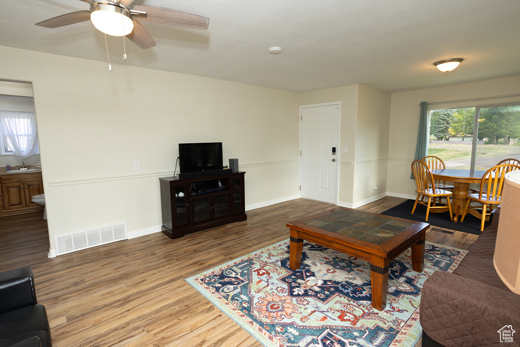 Living room with ceiling fan, sink, and wood-type flooring