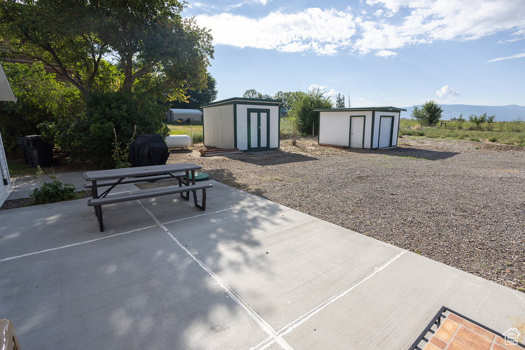 View of patio with a mountain view and a storage shed