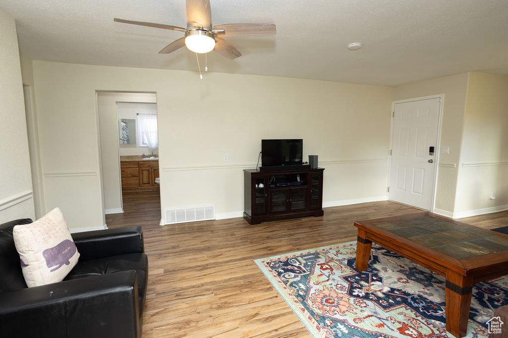 Living room featuring ceiling fan and light hardwood / wood-style floors