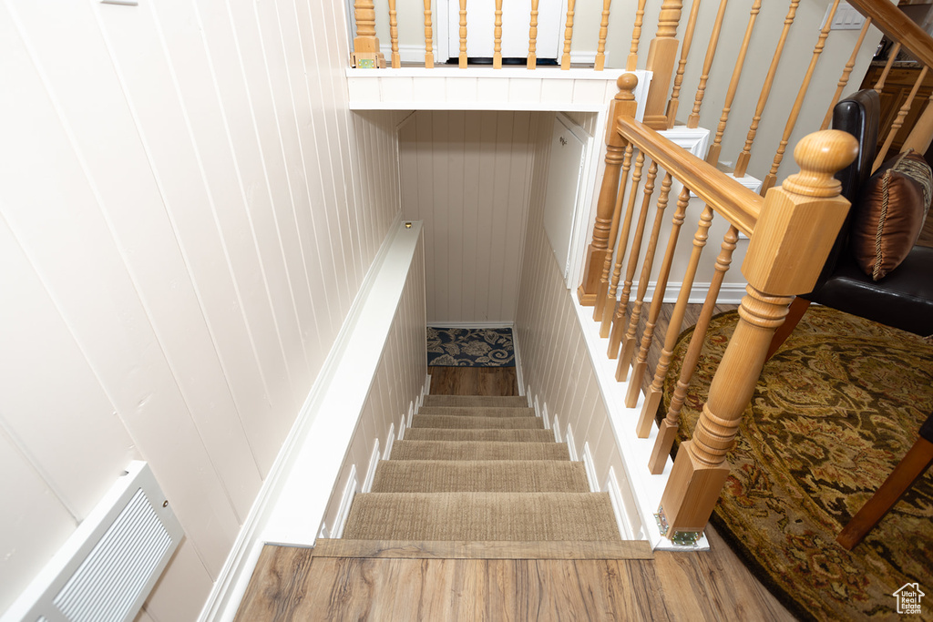 Stairs featuring hardwood / wood-style flooring