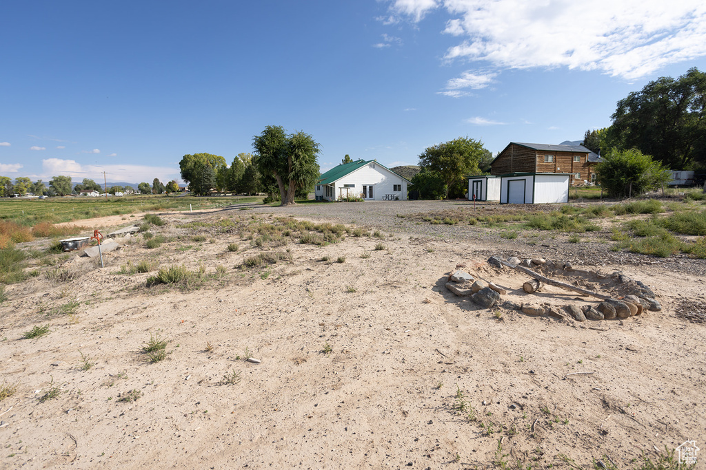 View of yard with a garage and a rural view