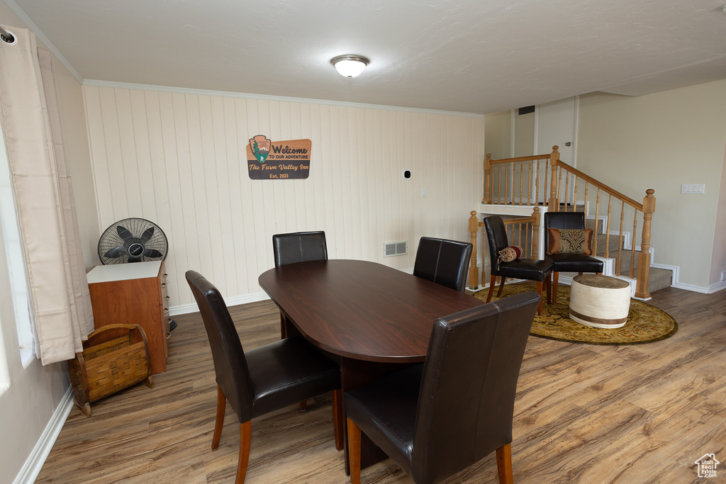 Dining area with wood-type flooring and wooden walls